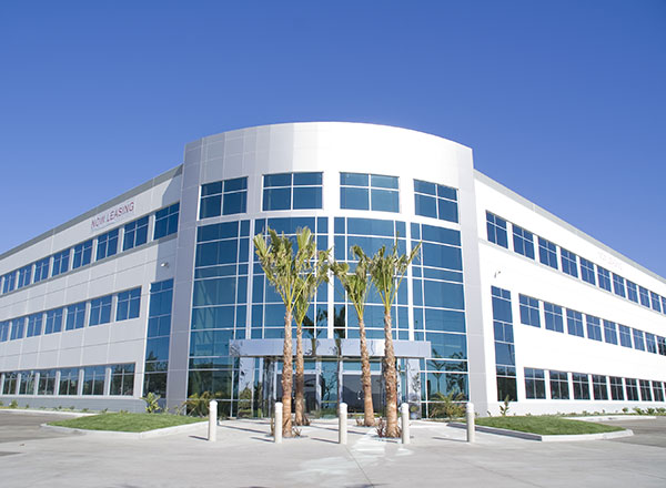 A large building with palm trees in front of it.