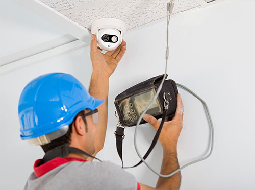 A man is holding up a camera to the ceiling.