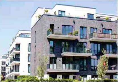 A building with balconies and plants on the outside.