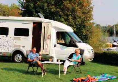 Two people sitting in front of a white van.